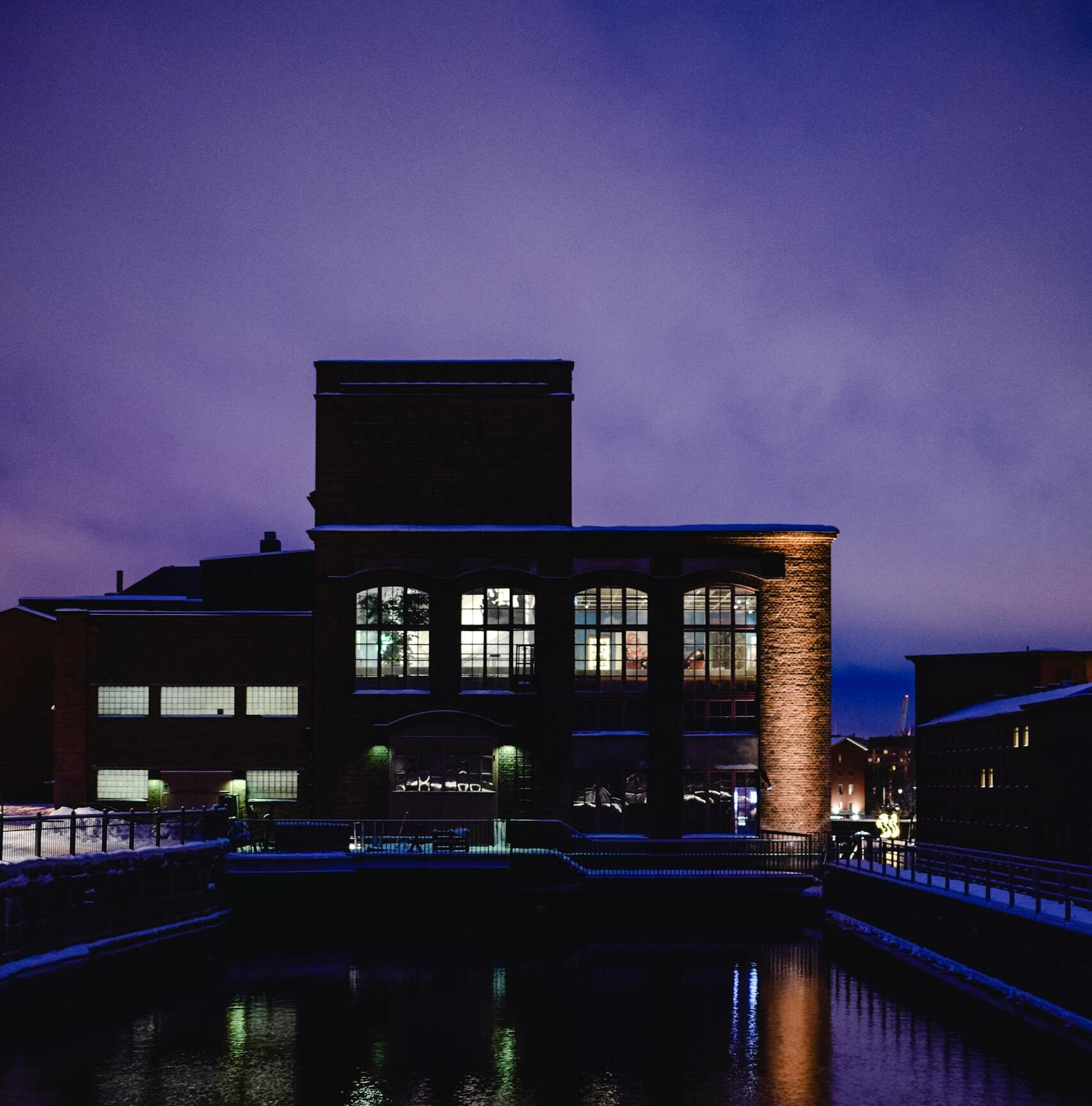 A stunning twilight view of Tampere's industrial architecture reflecting in water.